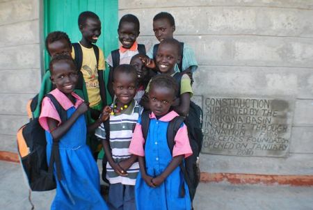 Students at Telesgaye Primary School standing in front of teachers' quarters funded by Ceres