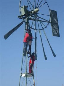 Ileret youth bringing down the old wind pump. Ileret youth bringing down the old wind pump.